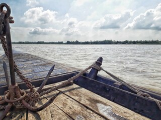 Fototapeta premium A boat with an anchor on it floating in a river on a sunny day