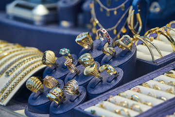 Jewelry shop window with a huge selection of gold jewelry bracelets, chains, rings and earrings