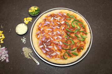 Delicious pizza in a pan with onion and capsicum