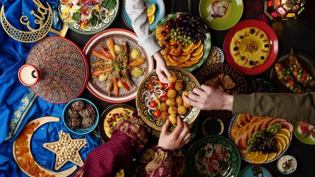 Table prepared for dinner in Ramadan with dates, lamb in tagine, hummus, samosa, falafel, pita bread. Muslim family dinner. Islamic holiday Eid al Fitr