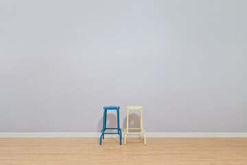 A blue chair and a beige iron frame chair are placed in a spacious living room