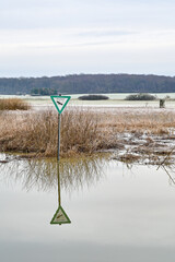 Schild eines Landschaftsschutzgebietes in Deutschland steht im Wasser des Hochwassers, Winter,...