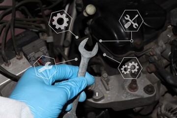 Automobile mechanic repairman hands repairing a car engine automotive workshop with a wrench