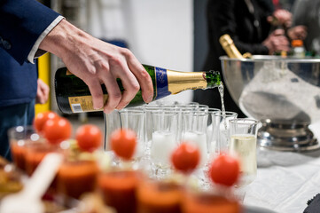 Main de serveur qui sert du champagne pendant un cocktail
