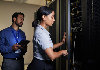 Server room, engineer teamwork and woman opening panel for maintenance or repairs at night....