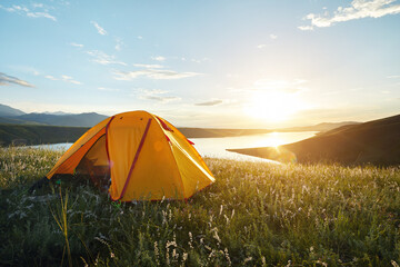 Camping yellow tent in the mountain lake