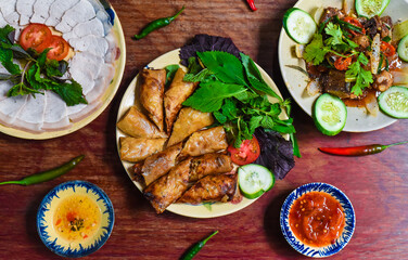 Traditional fried vietnamese spring rolls with pork, rice paper with sauces, meat slices and beef stew