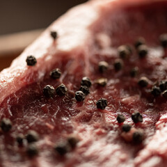 Piece of raw meat with spices. Fresh beef. Marble beef steak. Pickled meat. Peppercorns on surface...