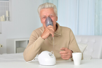 Portrait of sick old man with inhaler