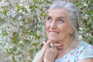 beautiful old woman posing in park in spring