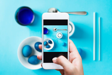 Dye blue easter eggs. Easter preparations. Colorful easter flat lay on blue background.
