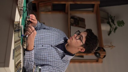 Male young technician student repairing computer motherboard at table at home. STEM engineering science education classes. Copy space.