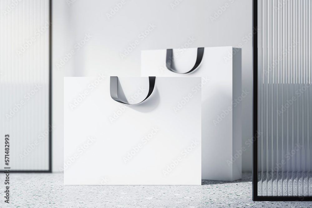 Poster front view on blank white paper shopping bags with space for your brand name or text on concrete flo