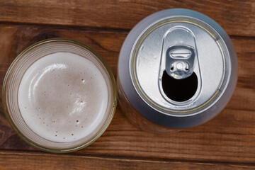 Beer can and beer glass on blurred background, top view