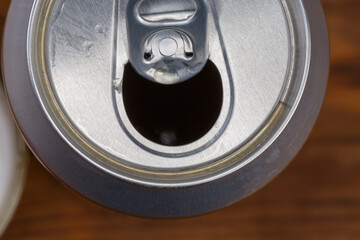 Top view of open beer can, fragment on blurred background