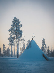 Very cold snowy arctic tundra with forest during sunset and a hut and frozen teepee_part1
