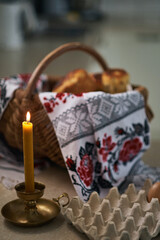Easter burning candle on the background of basket with embroidered towel. Ukrainian style High quality photo