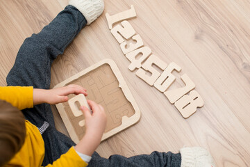 Puzzle numbers. boy playing with wooden numbers. Early education, verbal and memory game.
