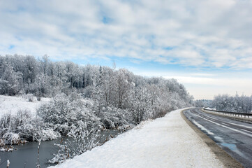 Obraz premium The road is covered with snow and ice for cars, a narrow road after snowfall.