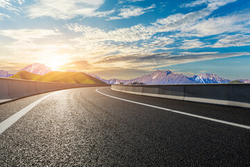 Asphalt road and mountain with sky clouds background at sunset © ABCDstock