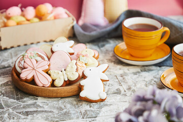 Aesthetics Easter glazed cookies and cup of tea on the decorated holiday table