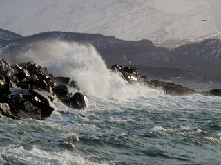 Waves over breakwater wall in Northern Norway