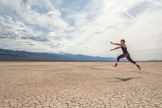 woman jumping over Death valley desert