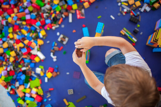 4 years boy building a tower with with interlocking plastic bricks