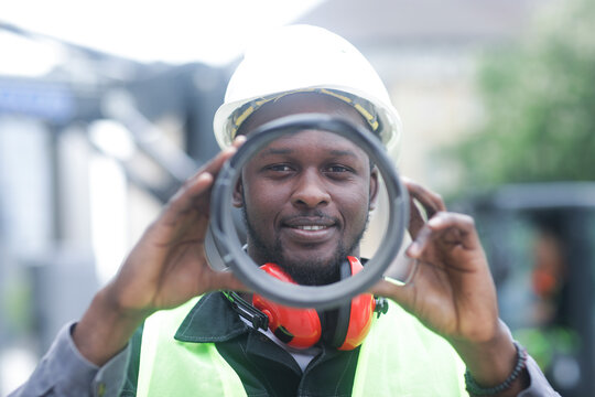 worker young male with helmet outside looking to a tube