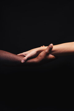 Male and female hands with different skin tones holding each other