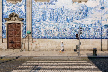 Tourist walking, azulejos tiles over Chapel Of Souls, Porto, Portugal - 571497574