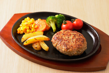 鉄板に盛り付けたハンバーグステーキ　