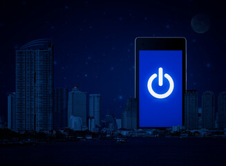 Power button flat icon on modern smart mobile phone screen over office city tower, river and...