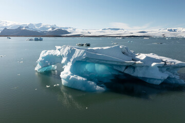 blue iceberg floating over glacier lake