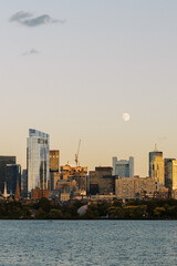 Obraz premium full moon over boston skyline at sunset charles river foreground