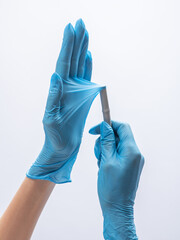 Isolated hands in blue medical gloves. Stretching of durable nitrile gloves on white background. Test of strength