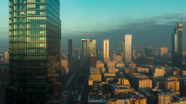 Shadows falling over the modern skyscrapers in the city of Warsaw during sunset on a winter day. Timelapse shot