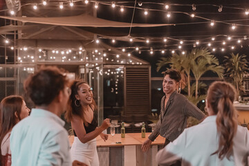 Group of friends having fun at rooftop pub and restaurant