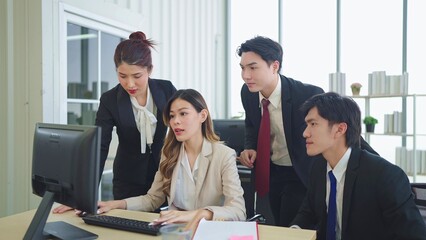 A group of young business people discuss and using computer while working together in a modern workplace