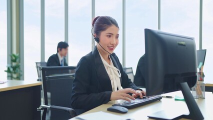 Young Asian woman customer support phone operator with headset working in call center