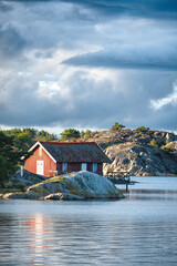 Fototapeta na wymiar Scandinavian house by the water under stormy sky