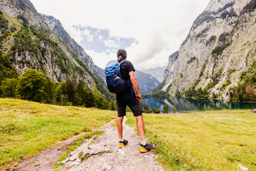 Man is hiking at Obersee am Königssee. beautiful Bavarian Landscape Behind and between the...
