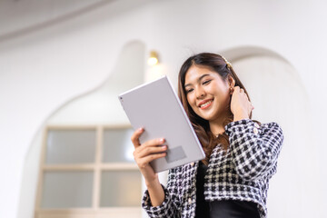 Portrait of smiling happy beautiful asian woman relaxing using digital tablet.Young asian girl looking at screen typing message and playing game online or social media at cafe