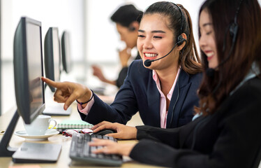 Group of happy call center smiling business operator customer help support team phone services agen working and talking with headset on desktop computer at call center office