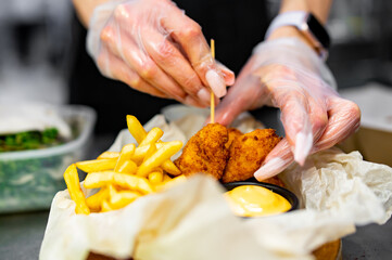woman chef cooking Chicken Nuggets with French Fries and sauce on kitchen