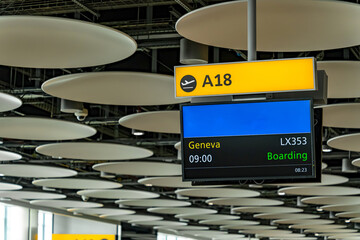 Airport boarding sign for flight to Geneva