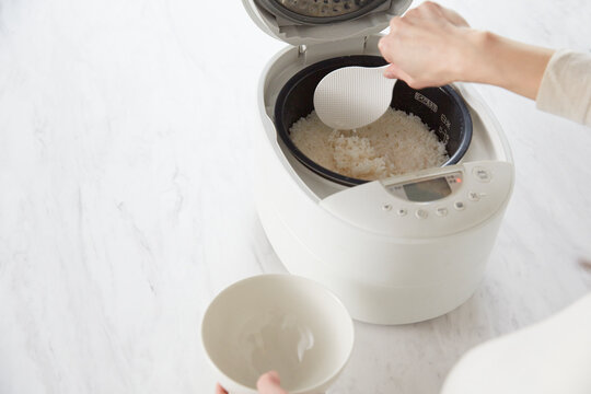 炊飯器のご飯をよそう女性