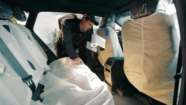 An engineer scans the car to accurately reproduce the car floor mats. 3D scanner for scanning surfaces.
