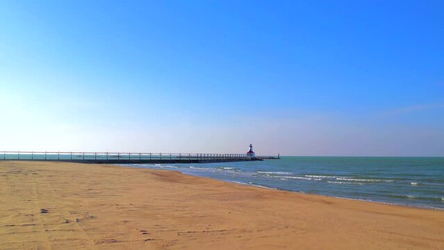 Lake Michigan lighthouse and pier, Indiana. Aerial approach and panoramic view. Blue sky for copy space