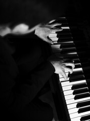 Pianist male hands playing music on piano keys.
